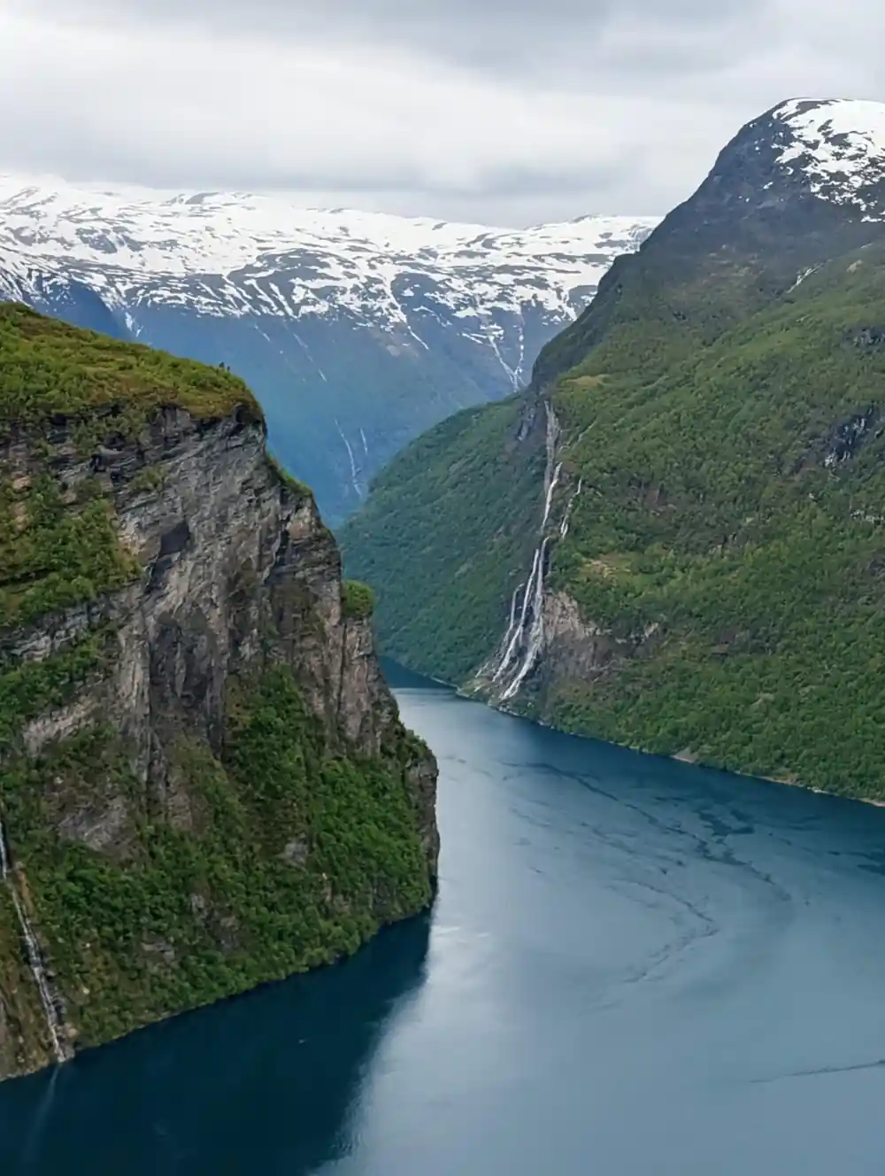 Aerial view of narrow fjord between steep forested mountains