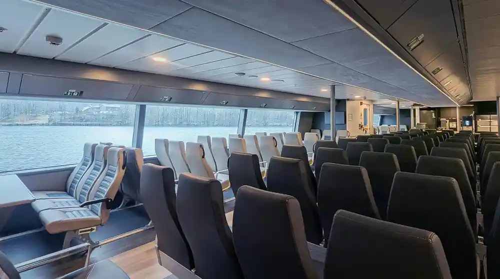 Interior of ferry with rows of seats and window