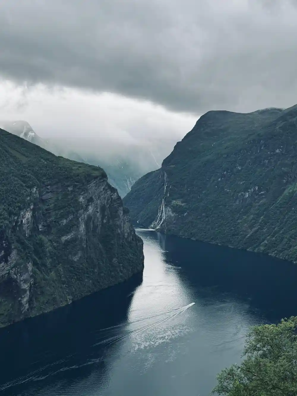Narrow fjord between steep cliffs with waterfall
