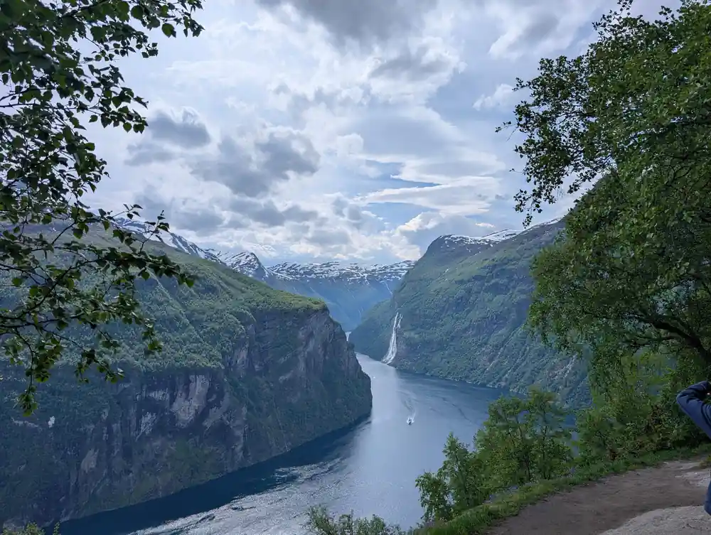 Narrow fjord between tall mountain cliffs with boat