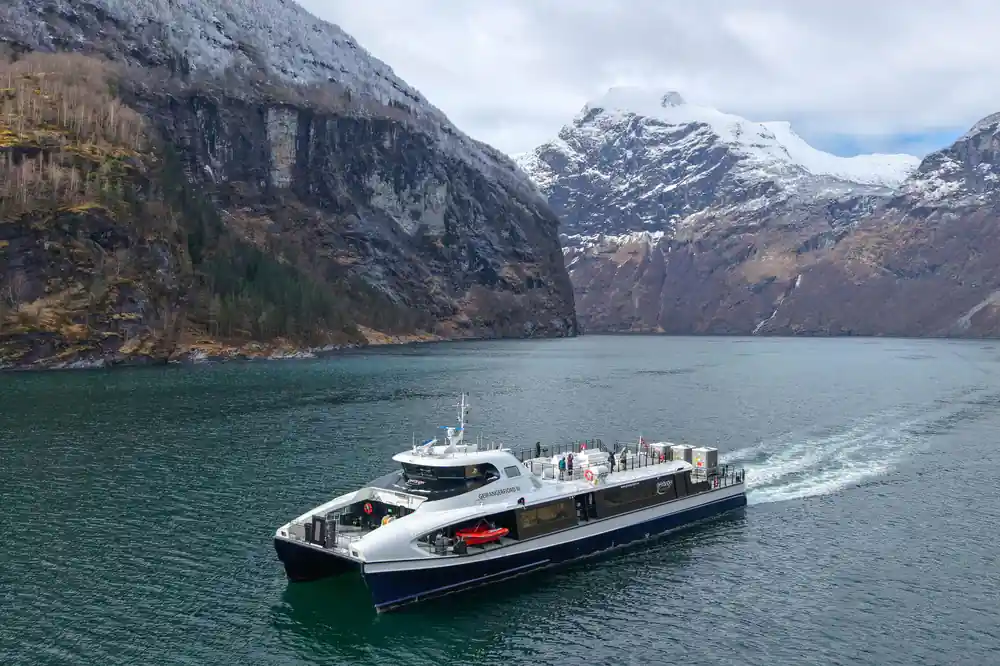 Passenger ferry on alpine lake with snow peaks