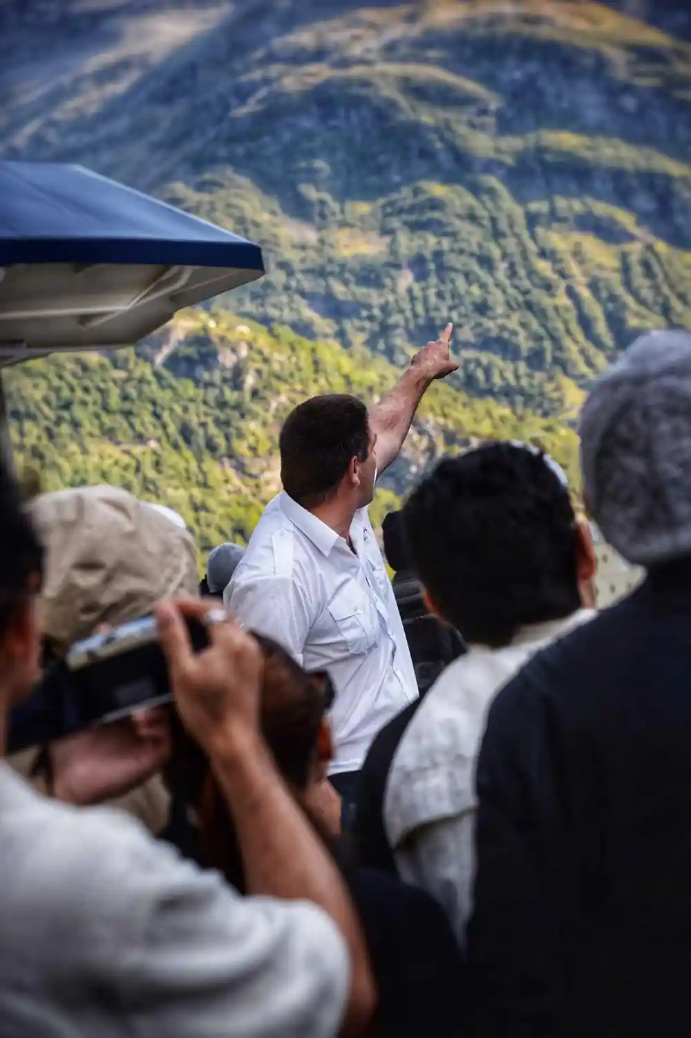 People on aircraft viewing forested mountainous landscape