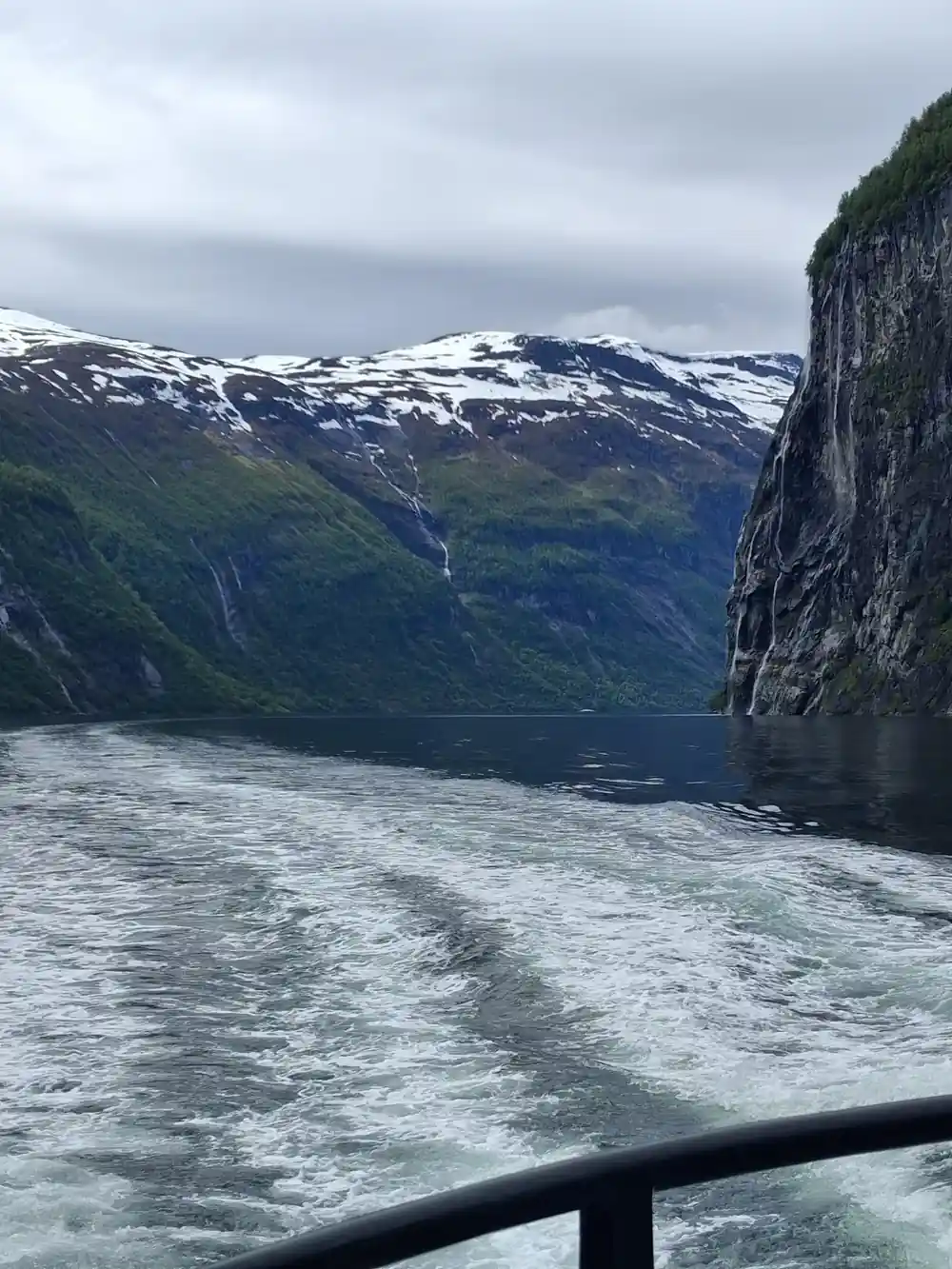 Snow-capped mountain peaks across blue fjord water