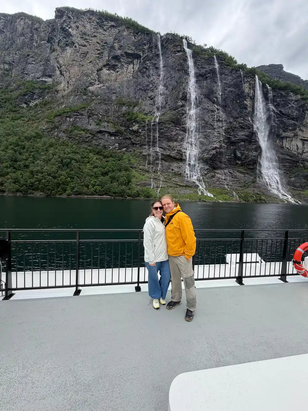 Two people on boat deck with multiple waterfalls behind