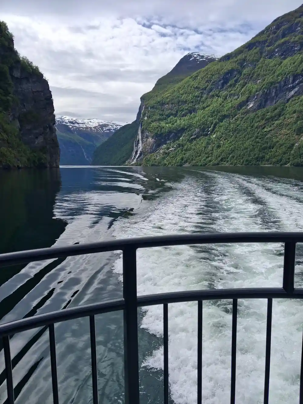 View from ferry of cliff and waterfall in fjord