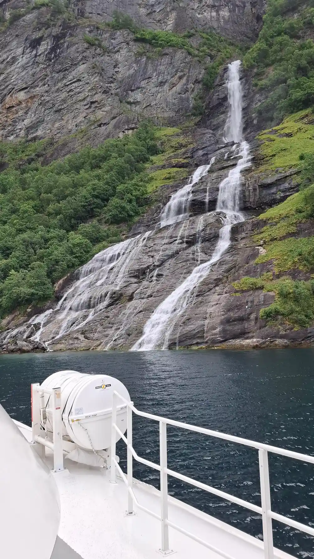 Waterfall streaming down rocky mountain into water